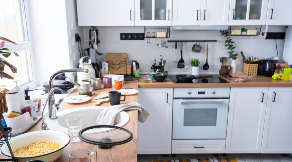 White kitchen filled with clutter on the countertops.
