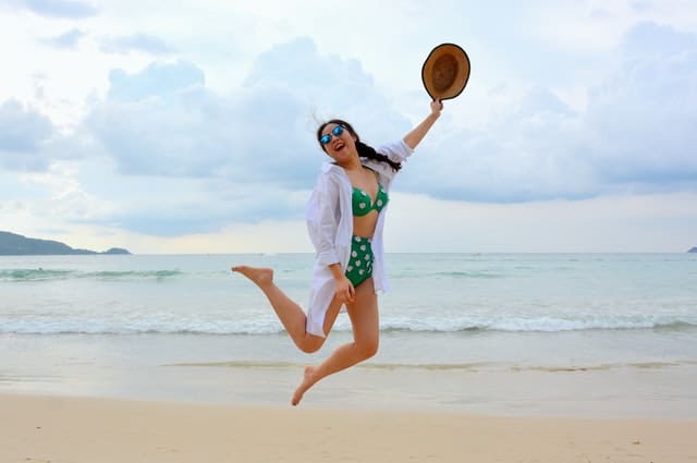 Happy woman at beach jumping