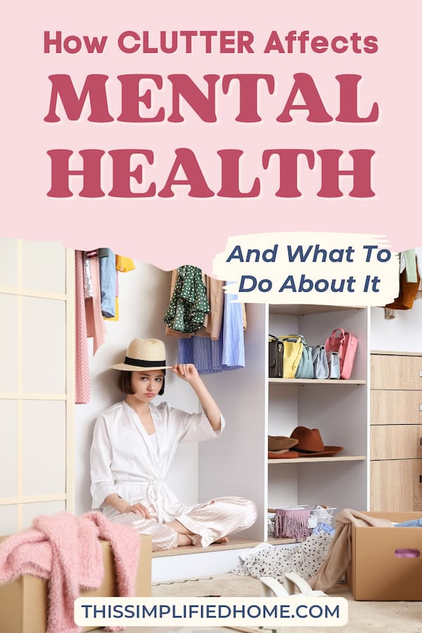 Woman sitting in a cluttered closet wearing pajamas and a hat, making a serious face at the camera.