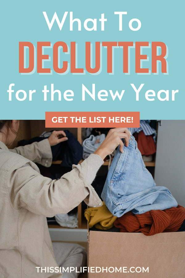 Back right side of a woman pulling clothes out of a closet and putting into a box as she declutters for the New Year.