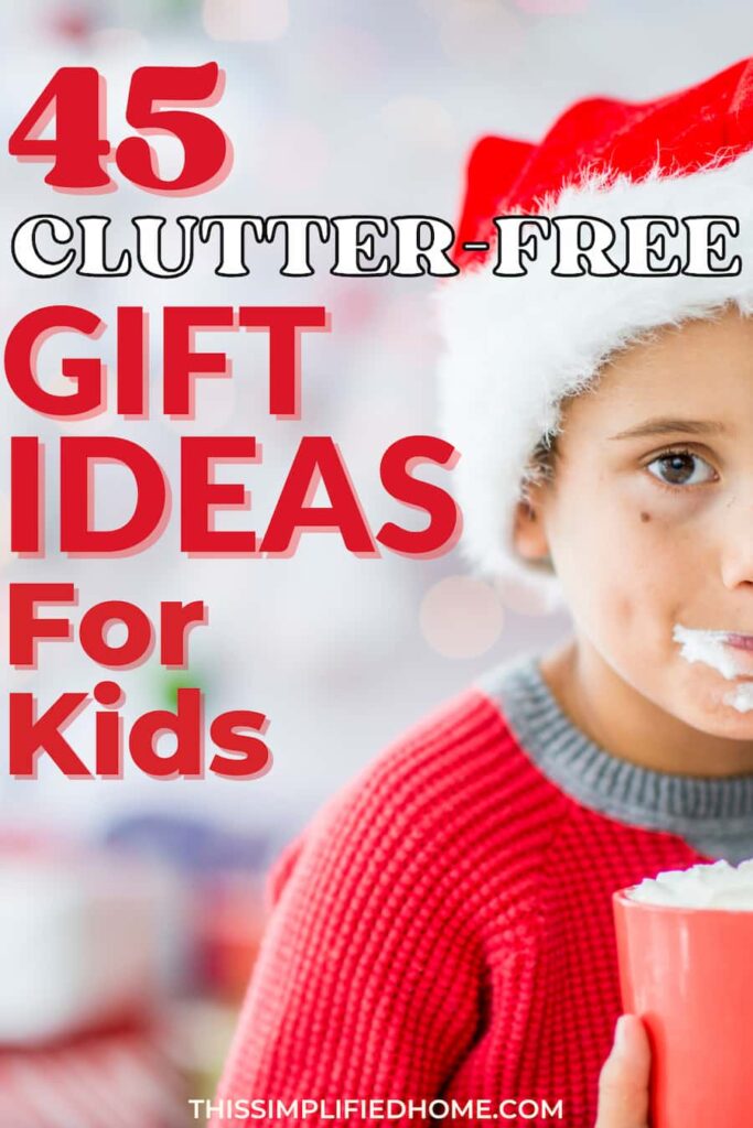 Child wearing a Santa hat drinking hot cocoa with whipped cream. The whipped cream is all over his face.